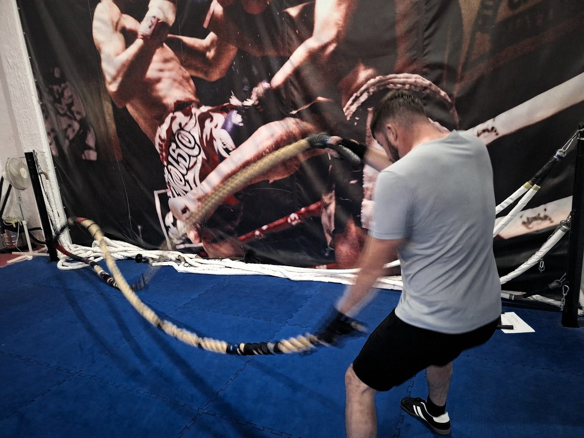 Kötélgyakorlat a kék szőnyegen, a háttérben a Muay Thai falfestmény